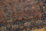 Vintage Persian Yezd rug's indigo main border with floral relief and Farsi inscription cartouches.