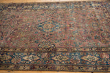 Vintage Yezd rug border showing indigo field, Farsi cartouches, and floral relief.