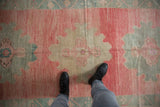 Distressed Oushak runner showcasing even wear, faded pink, and oxidized silver medallion.