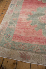 Distressed vintage Oushak runner's pink field and oxidized silver scalloped border.