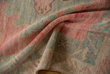 Folded texture of a distressed Oushak rug runner in dusty blush and oxidized silver.