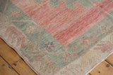 Distressed Oushak runner corner with dusty blush field and oxidized silver meandering floral border.