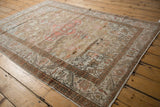 Intricate geometric starburst and meandering vine borders on a distressed Turkish Kaisary rug.