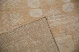 Distressed Oushak rug showing short pile texture, woven foundation, and intact side selvage.