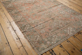 Distressed vintage Melas rug, showing geometric motifs in faded dusty rose and oxidized silver tones.