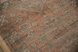 Distressed vintage Melas rug pile showing pale dusty rose and oxidized silver guls.