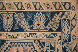 Distressed Melas rug close-up: cobalt blue geometric patterns on a beige border, showing soft texture.