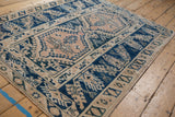 Vintage distressed Melas rug edge, showcasing geometric cobalt blue and beige patterns.