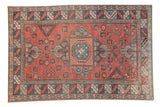 Distressed vintage Melas carpet, central pomegranate medallion, geometric patterns in brick red, sky blue, ivory.