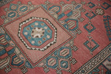 Distressed Melas carpet with angular geometric buds in sky blue, pale rose, and cherry red.