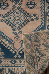 Distressed Melas rug, showing geometric patterns, worn pile texture, and reverse weave.