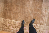 Distressed Kars carpet detail showing muted seed pattern and pink floral border.
