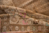 Distressed vintage Kars rug, soft coffee brown texture, with pink and teal geometric patterns.