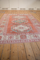 Distressed Oushak rug with pale cinnabar, ivory gul medallions and geometric floral border.