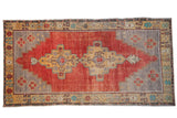 Distressed vintage Oushak carpet, dusty cherry red field, stepped geometric medallion.