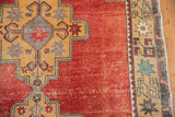 Distressed cherry red pile, geometric starbursts, and original selvage on a vintage Oushak.