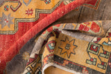 Dusty cherry red and saffron geometric patterns on a worn Oushak rug pile.