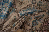Distressed Oushak runner texture revealing pale blue geometric guls and brown border patterns.
