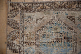 Distressed pile of the Oushak rug with geometric guls and sky blue highlights.