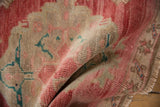 Distressed vintage Oushak rug texture, showing pale cochineal red and sand.