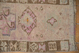 Hand-knotted texture and even wear of a distressed Kars rug with mauve and brown patterns.