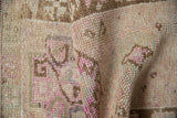 Close-up of a distressed Kars rug folded to show its hand-knotted pile and texture.