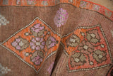 Vintage Kars runner fold, highlighting distressed texture and geometric patterns in tangerine orange, mauve.