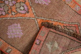 Distressed vintage Kars rug pile with geometric patterns and sturdy side selvage.