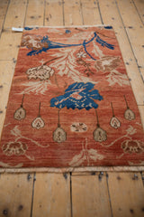 Distressed vintage Oushak rug texture, showing arts and crafts floral patterns in brick red and cobalt blue.