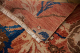 Folded vintage Oushak rug showing fringe, distressed pile texture, and red, blue, beige hues.