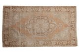 Vintage Distressed Oushak rug, cameo medallion, Rococo outlines, muted sandalwood, seafoam, ivory tones.