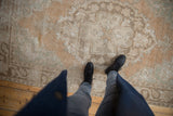 Distressed vintage Oushak rug texture, showing exposed knot heads and faded sandalwood, seafoam.