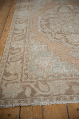Distressed Oushak rug corner detail, secured fringe and Rococo pattern in sandalwood, seafoam.
