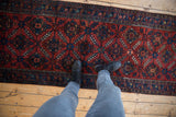 Hand-knotted vintage Lilihan runner, displaying ruby red and sapphire blue patterns with feet.
