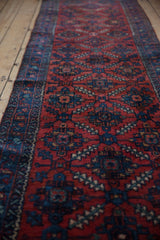 Ruby red field of the vintage Lilihan rug with intricate sapphire blue palmette and serrated leaf motifs.