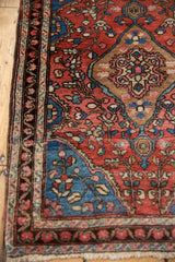 Detail of antique Farahan Sarouk rug's brick red floral border and sapphire blue serpent motif.