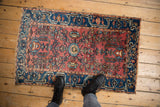 Vintage Lilihan rug corner detail: dusty red abrash field, indigo border, and fringe.