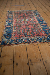 Vintage Lilihan rug corner showcasing intricate indigo blue border and cochineal red field vines.