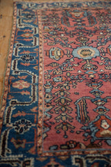 Vintage Lilihan rug's wide indigo border with intricate design and cochineal red floral field.