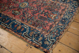 Detailed corner of a Vintage Lilihan rug, showing abrash, delicate floral vinery, and indigo border.