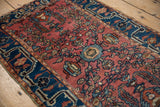 Vintage Lilihan rug border with intricate indigo pattern and dusty cochineal abrash field.
