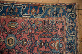 Dusty cochineal red Lilihan rug field with delicate floral vinery and indigo blue border.