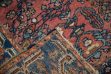 Intricate hand-knotted backing and dusty cochineal floral pile of a vintage Lilihan rug.