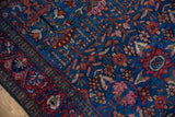 Finely woven Lilihan rug detail with sapphire blue field, germinating blossom motif, and brick red accents.