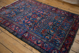 Vintage Lilihan rug corner detail showing sapphire blue germinating blossom field and red border.