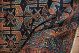 Intricate cobalt blue and dusty copper shrimp design motifs on a hand-knotted antique Hamadan rug pile.
