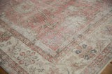 Distressed Turkish Sivas carpet corner showing faded rose, ivory curvilinear patterns, and worn texture.