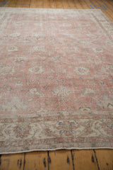 Faded rose and ivory palmettes on a distressed Sivas carpet, showing visible wear and foundation.