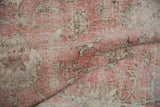 Distressed rose and ivory Sivas carpet showing mostly even pile wear with visible foundation.