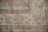 Distressed vintage Sivas carpet detail: worn rose and ivory palmettes with foundation showing.